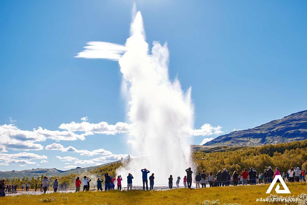 tourists watching geysir eruption