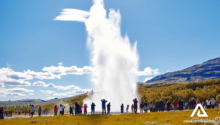 tourists watching geysir eruption in iceland