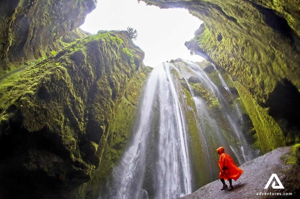 standing with a raincoat near gljufrabui waterfall