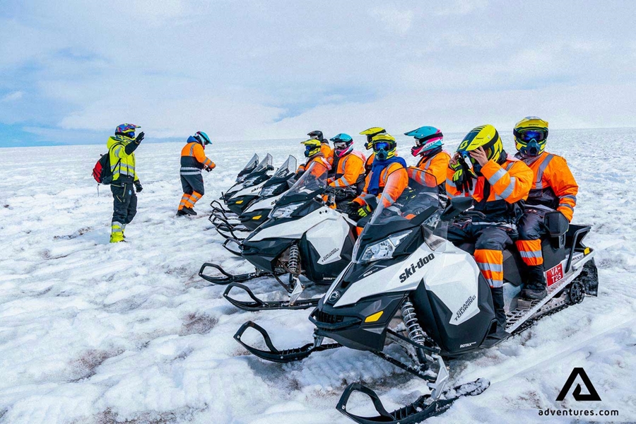 a group getting ready to snowmobile