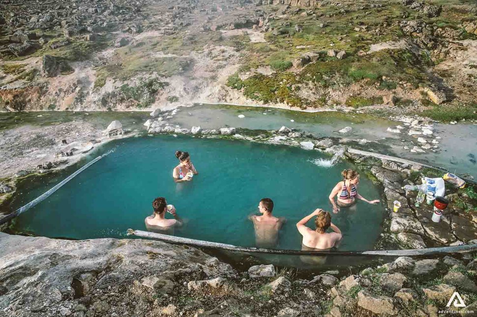 people bathing in hveravellir hot spring in iceland