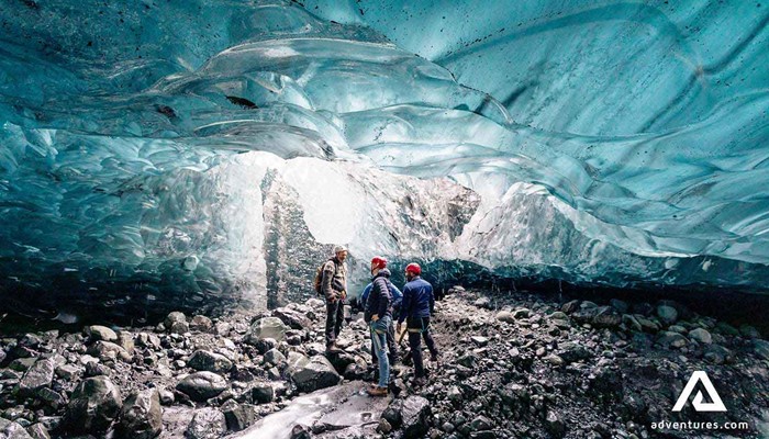 three men exploring crystal ice cave on breidamerkurjokull