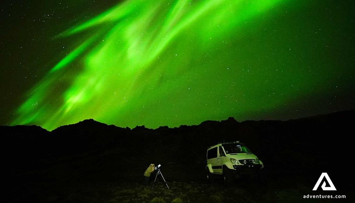 watching norther lights near a super jeep in iceland