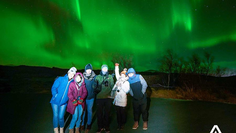 group of friends watching aurora borealis