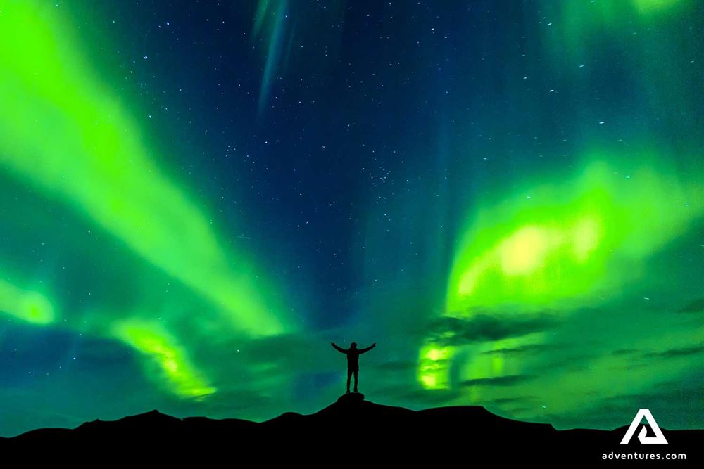 silhoutte of a person near northern lights