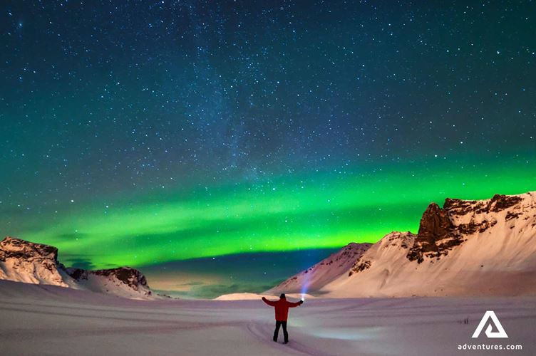 man with a flashlight watching northern lights man with a flashlight watching northern lights in winter