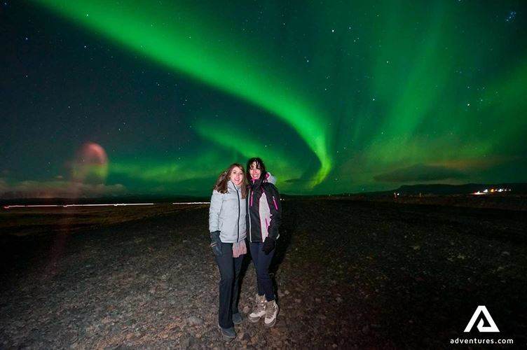 two women posing for a picture two women posing for a picture near northern lights