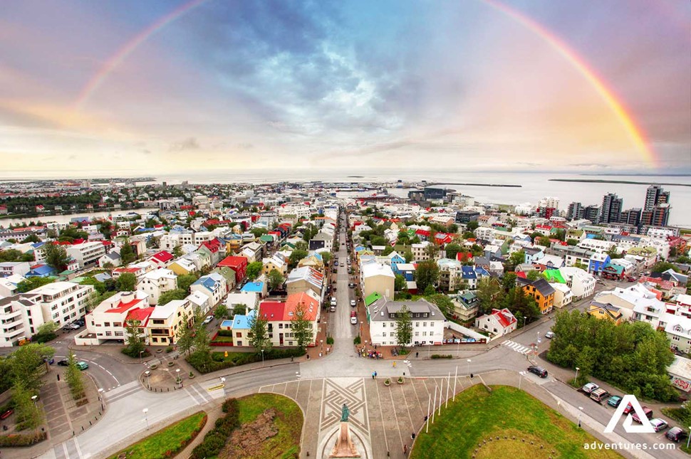 rainbow above reykjavik city streets at sunset