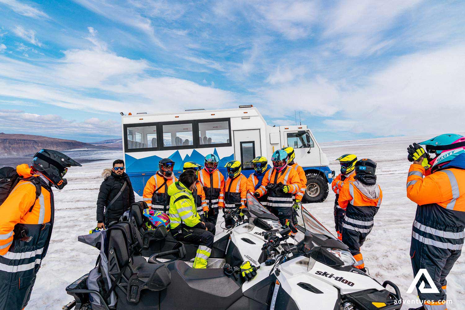 group gathered near snowmobiles