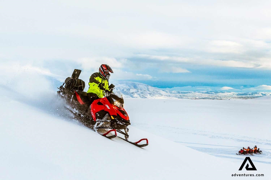 riding with a snowmobile down a mountain
