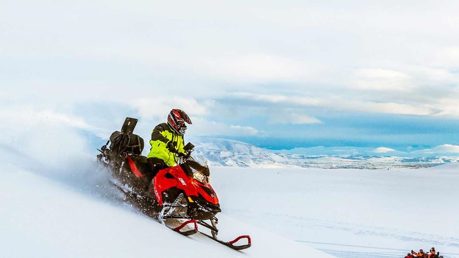 riding with a snowmobile down a mountain