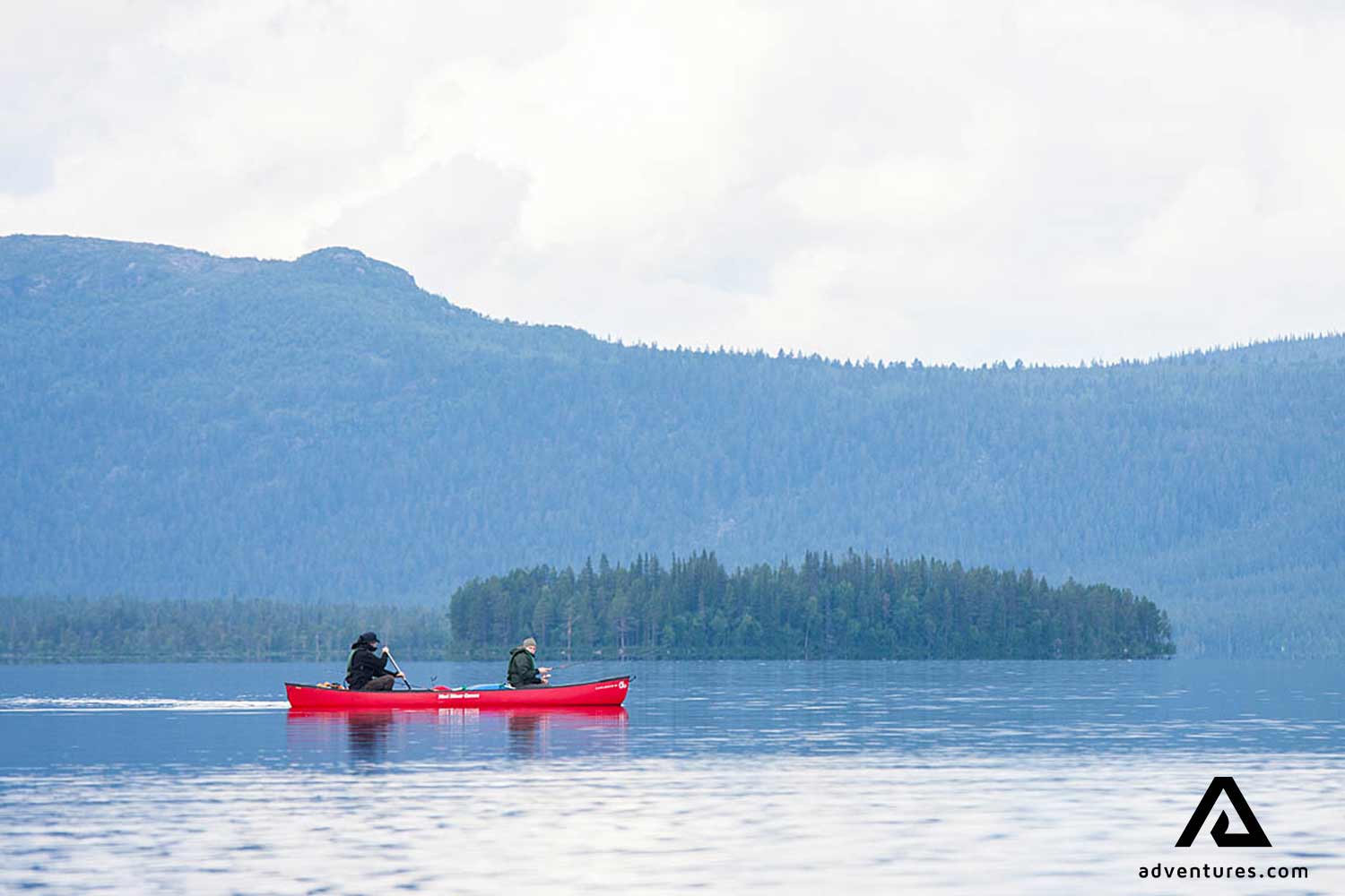 friends canoeing in a forest lake in lapland