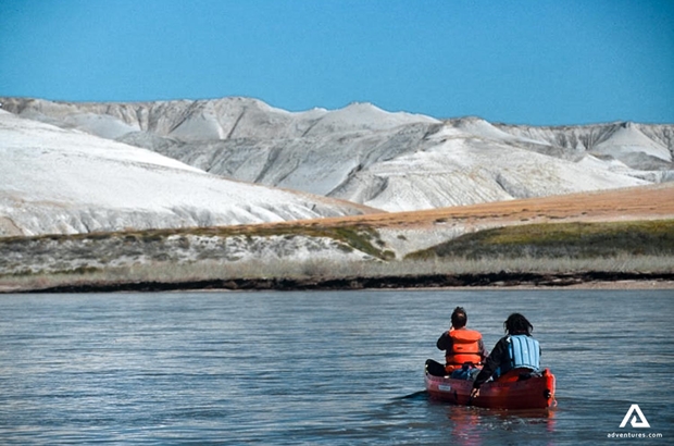 couple canoeing in horton river in canada