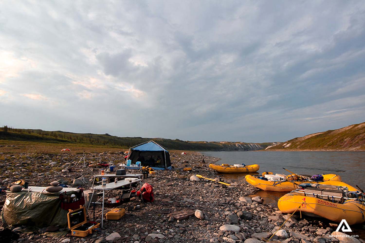 canoes and a tent on a river shore in canada