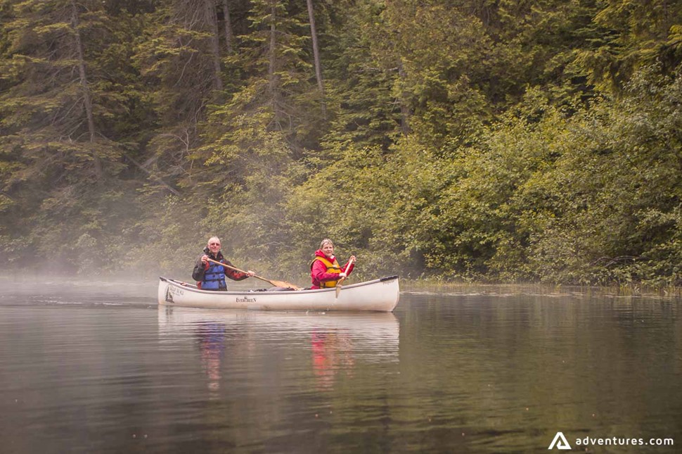 canoeing in a lake on a foggy morning in canada