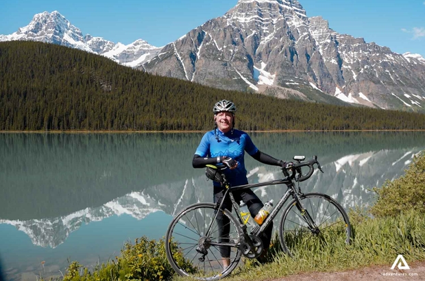 cyclist posing near rocky mountains at summer