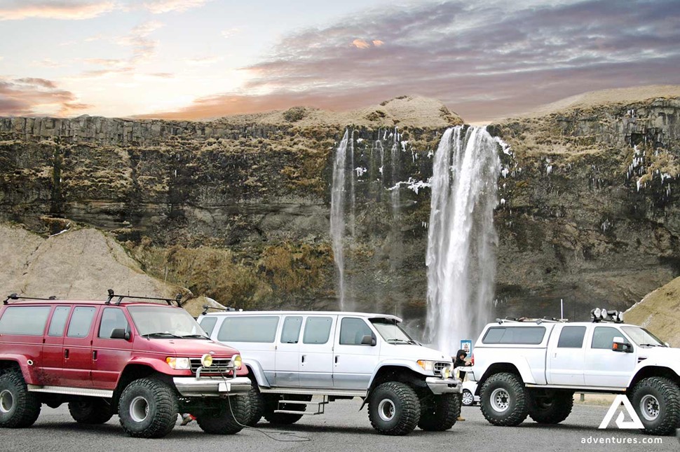 super jeeps parked near seljalandsfoss waterfall