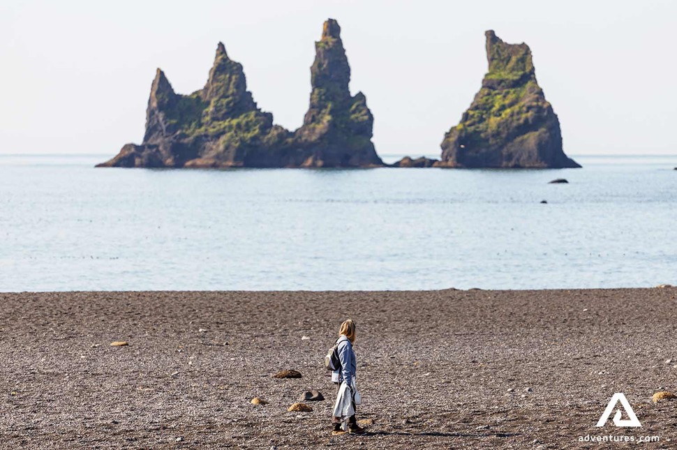 woman walking on reynisfjara black sand beach