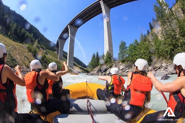 group rafting in a powerful river stream under a bridge