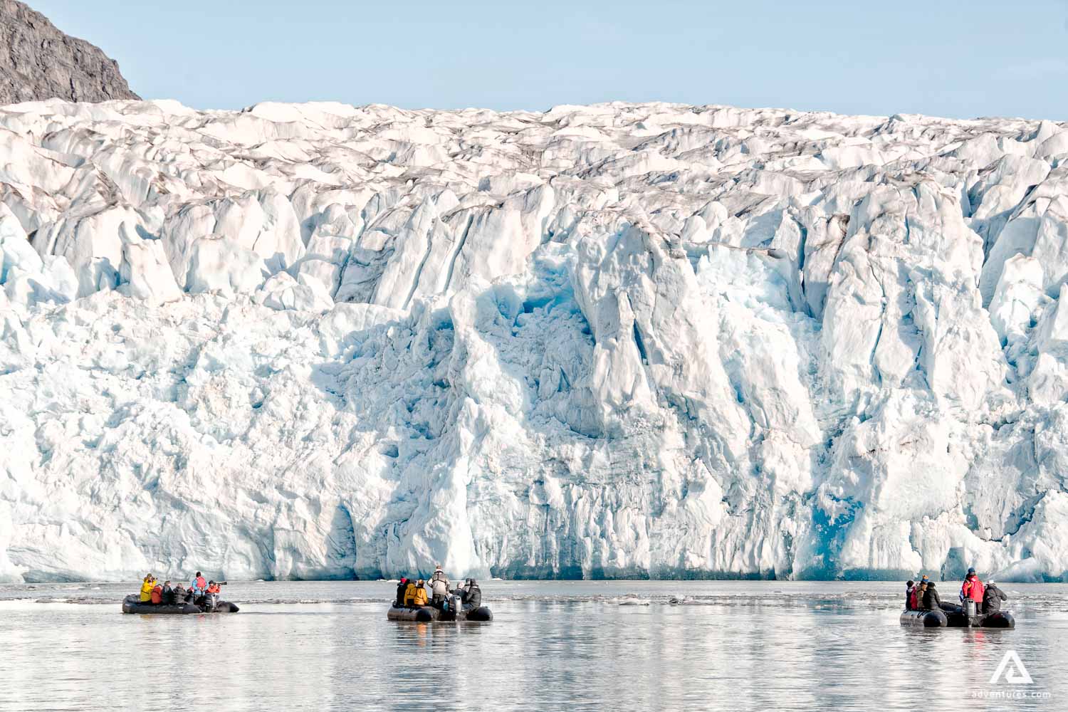 zodiac boats near a large glacier