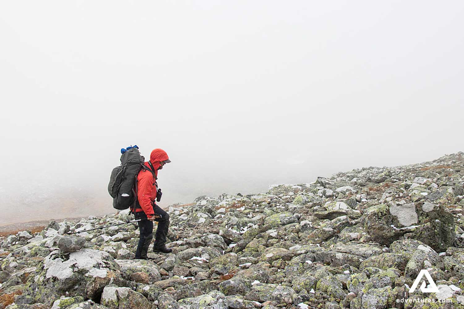 man hiking to the top of the mountain in sweden