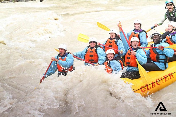 excited group on a rafting tour in a river