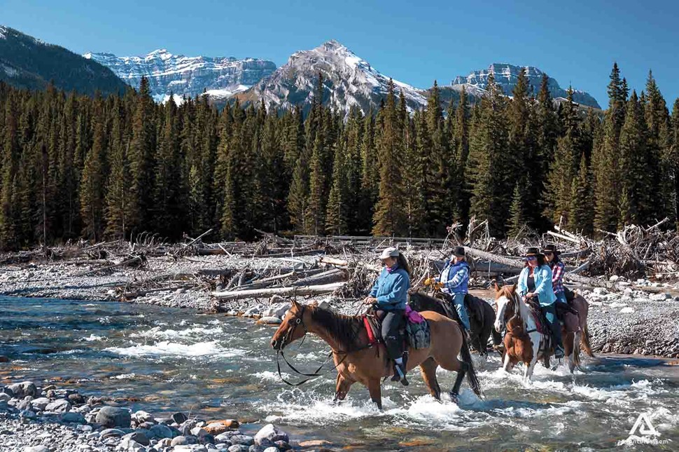 crossing a river on horses in canada