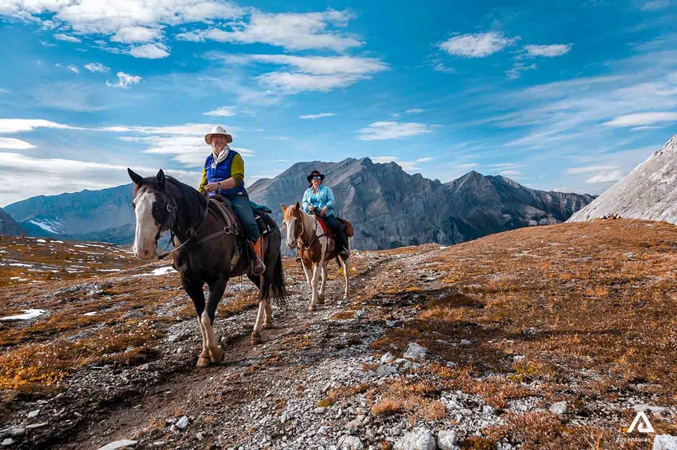 horse riders in rocky mountains in canada
