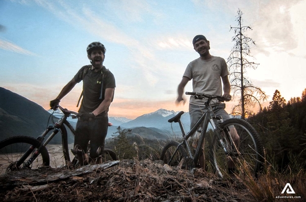 two men with mtbs at sunset