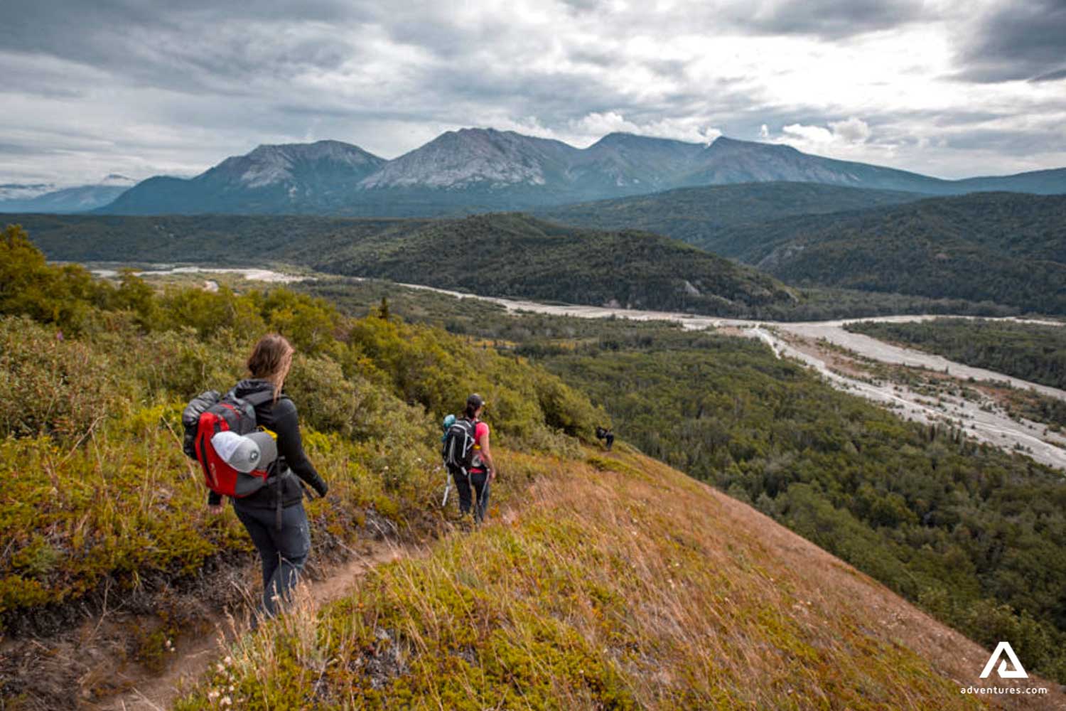 hikers walking down a mountain in canada