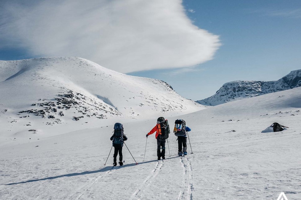 three people skiing uphill in canada