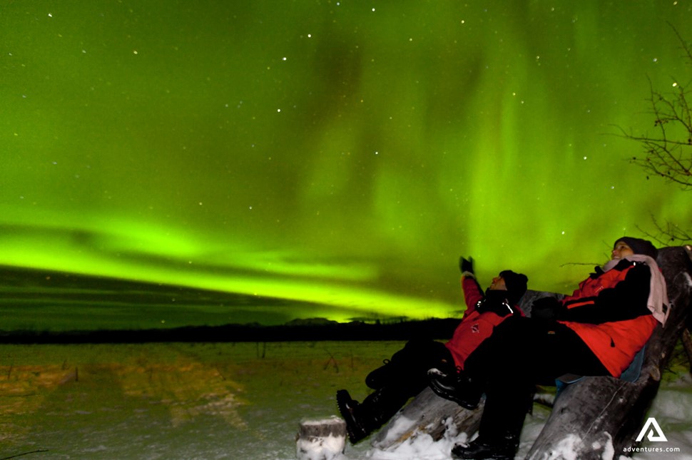 sitting and watching aurora borealis at night in canada