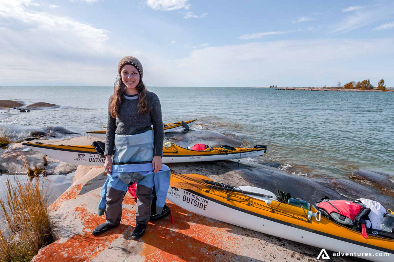 Happy girl near kayak on the lake shore