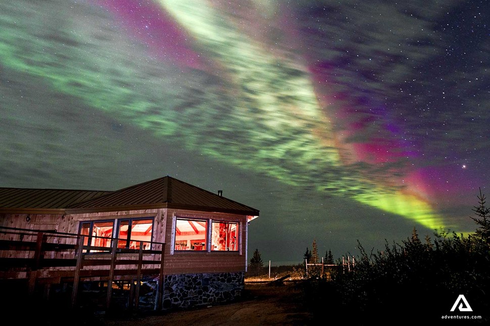 northern lights above a winter lodge