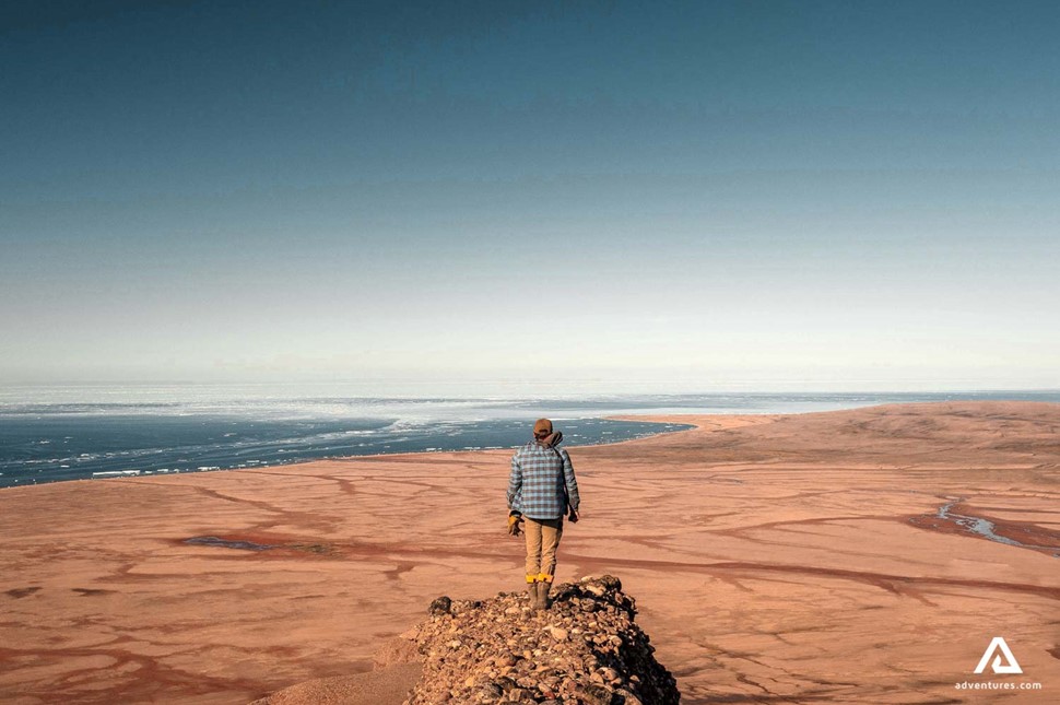 hiker on top of a mountain near a desert