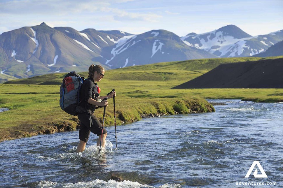 crossing a river on laugavegur trail in iceland in summer