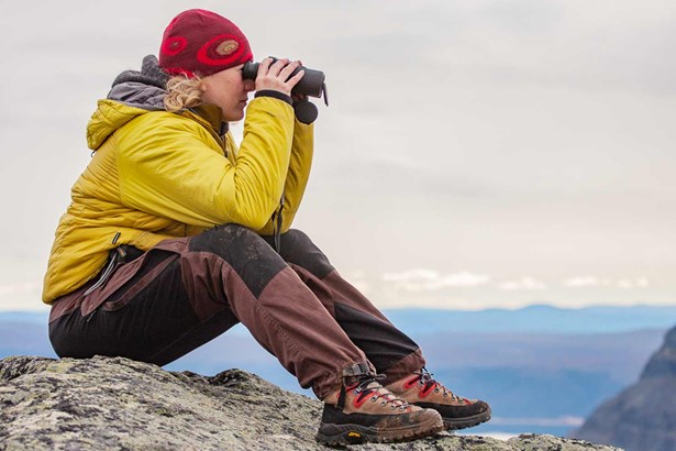 hiker woman with binoculars in sweden