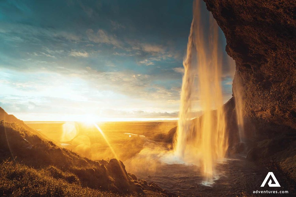 bright sunset behind waterfall in south iceland