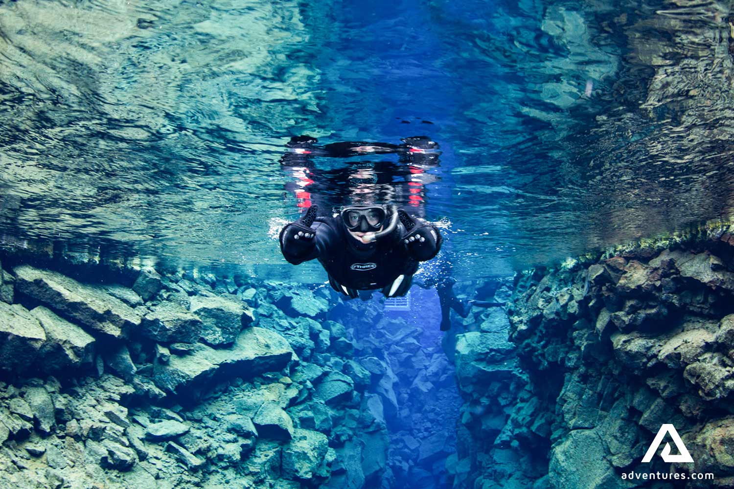 a man snorkeling and showing thumbs up in silfra