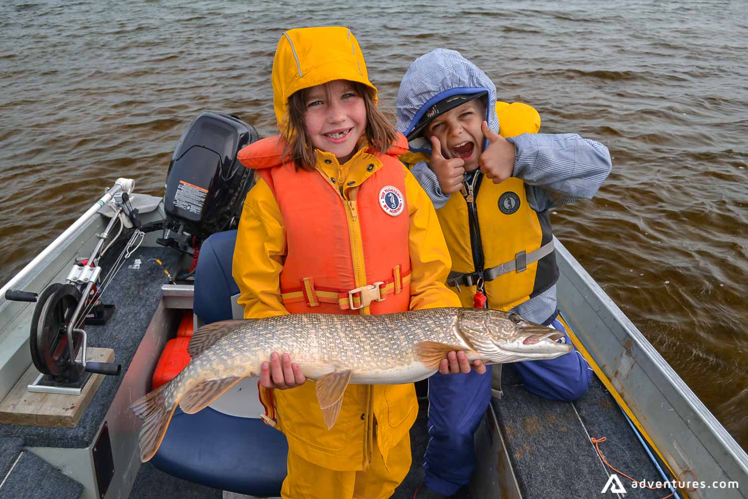 Happy kids catch fish in a boat