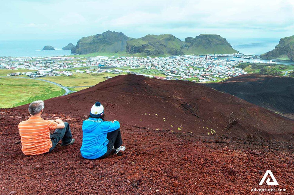 people resting on top of eldfell volcano