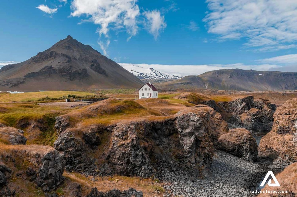 house in arnarstapi near mountain range in iceland
