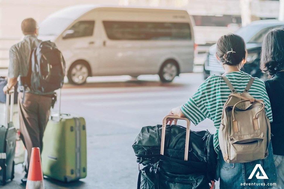 people leaving the airport with luggage