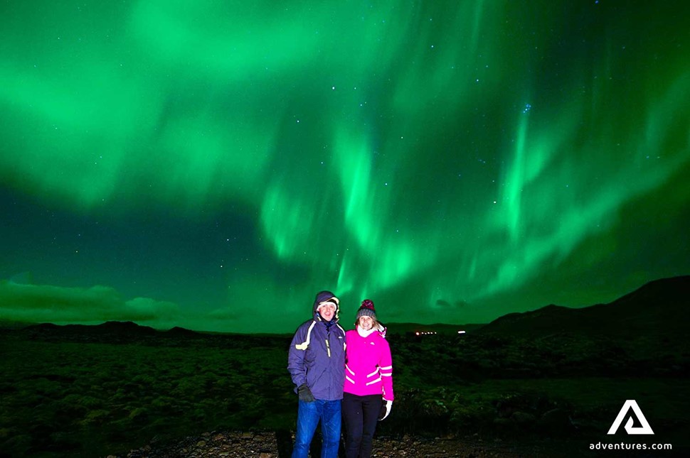 couple watching northern lights in iceland in winter