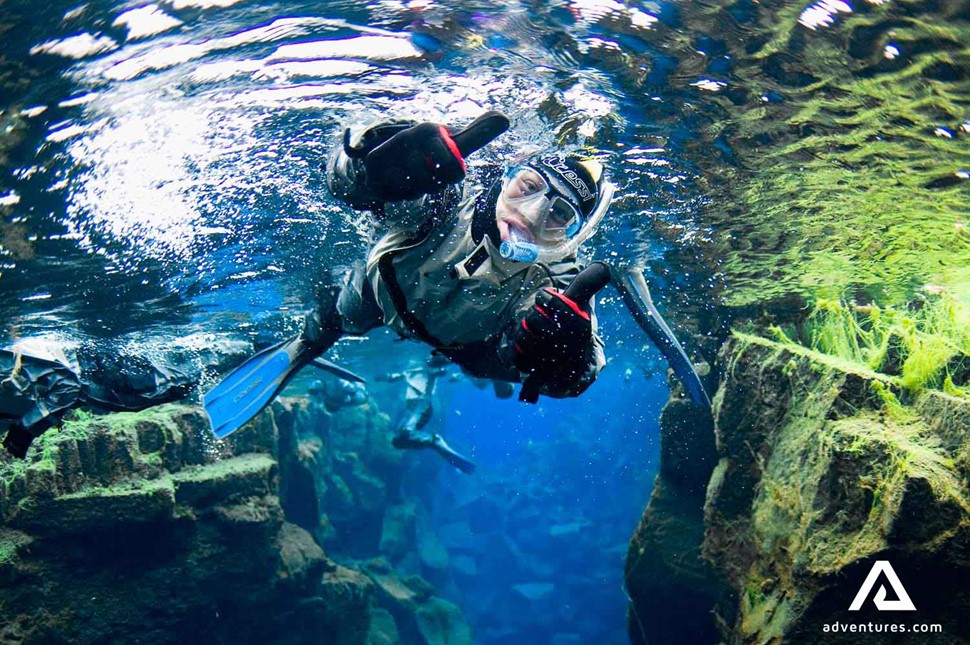 man showing thumbs up while snorkeling in thingvellir