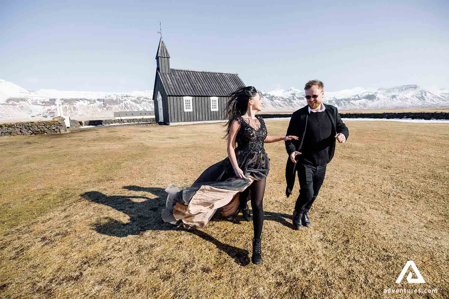 couple running near budir black church in snaefellsnes