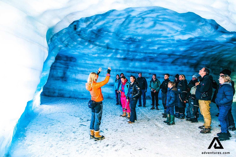 group of people with a guide on tour into the glacier