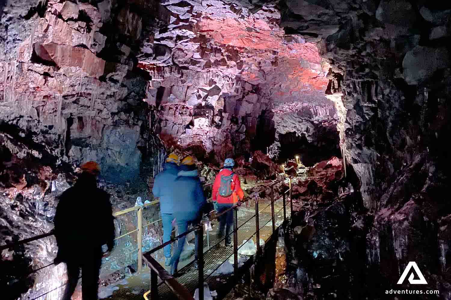 people walking inside a lava tunnel in iceland