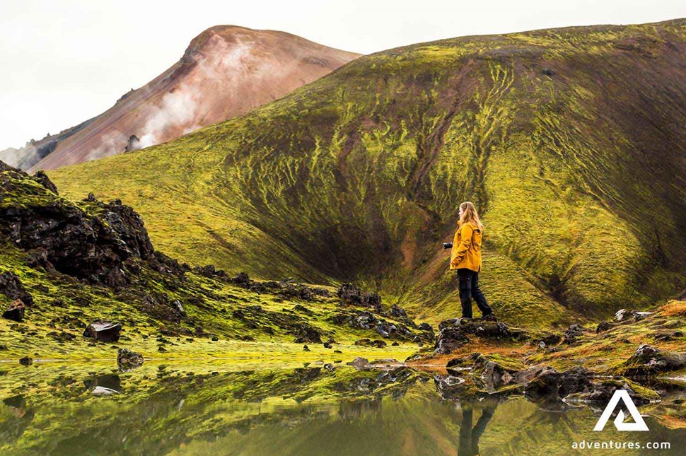 woman with camera hiking in icelandic highlands