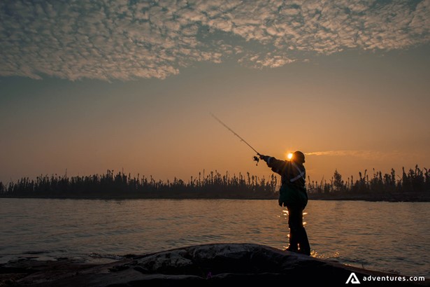 Man fly fishing at sunset
